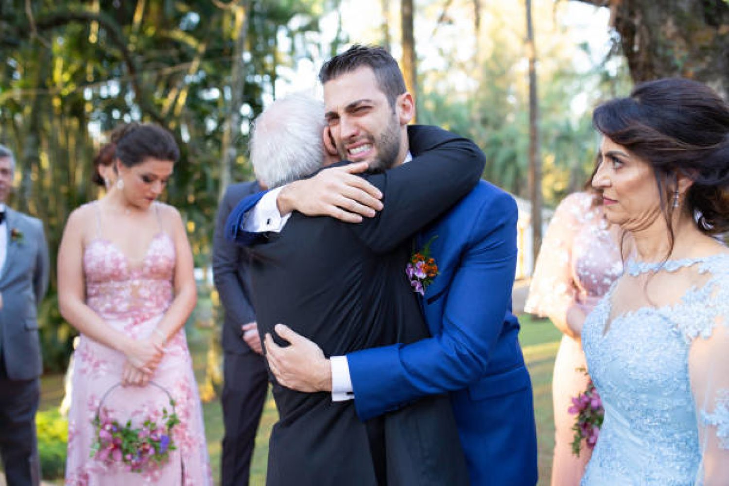 Emotional groom being congratulated by the wedding guests